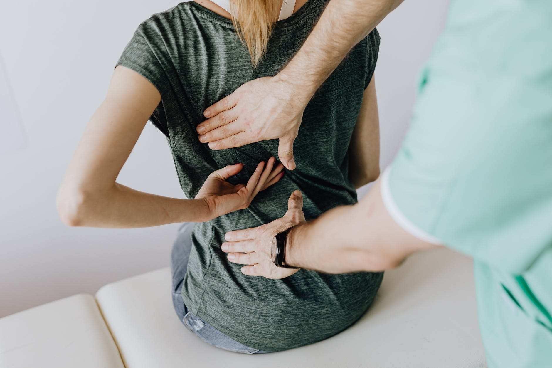 doctor examines woman s back rückenschmerzen lws