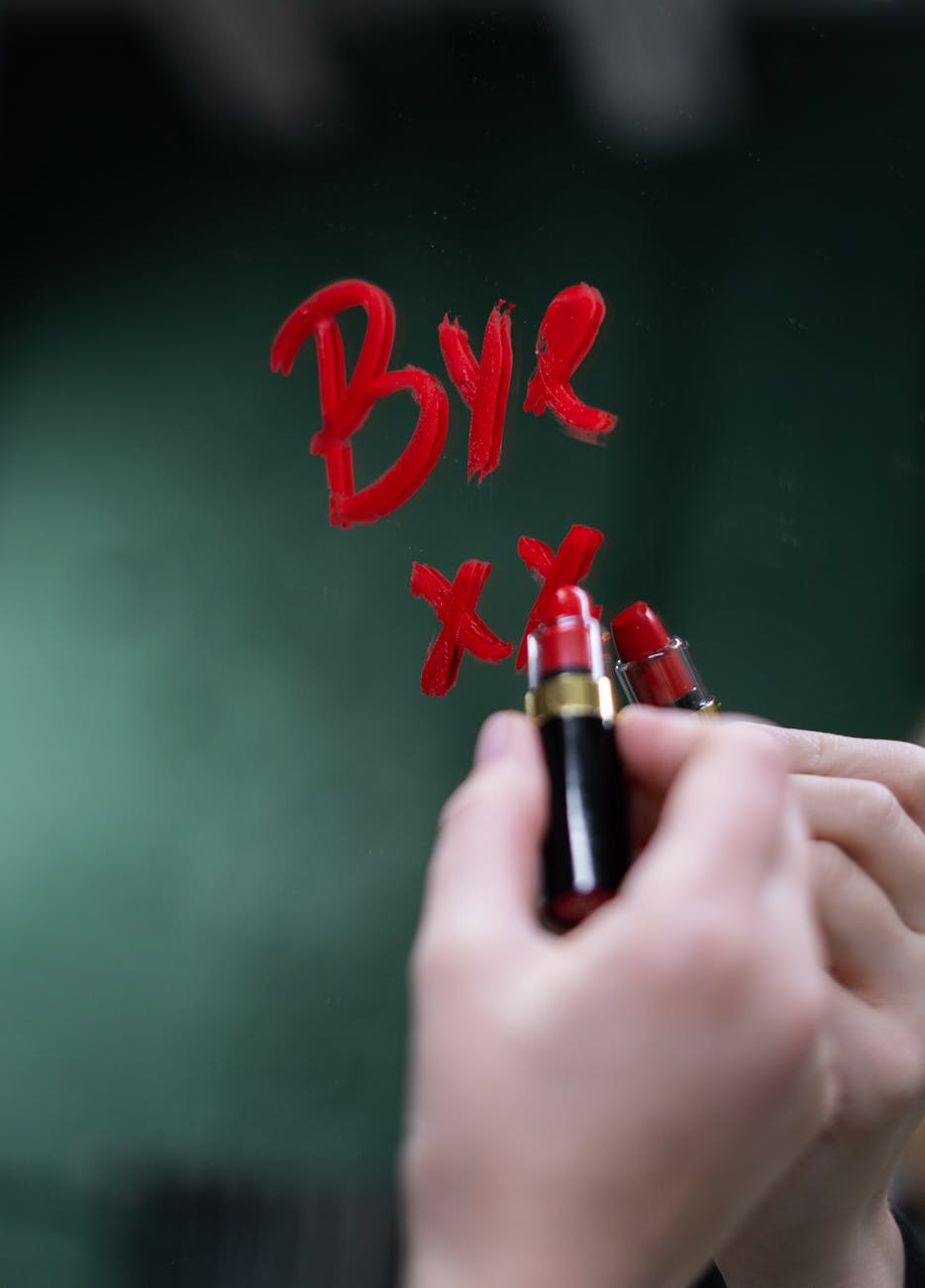 person holding red lipstick ghosting