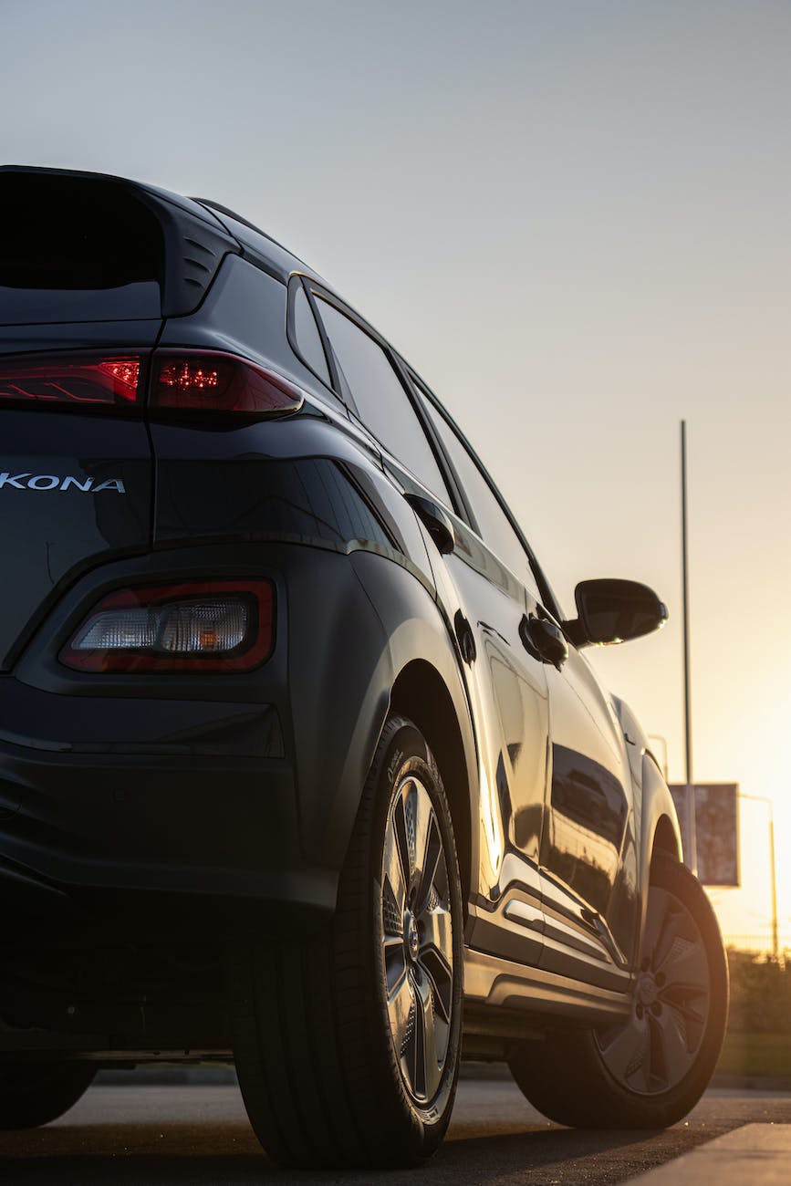 a low angle shot of black hyundai kona car parked on the street