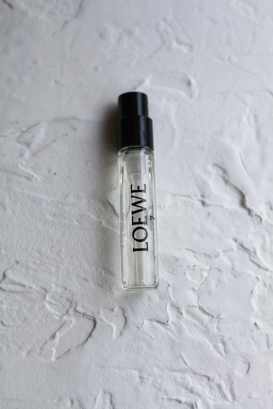clear glass spray bottle with perfume on white surface parfumproben